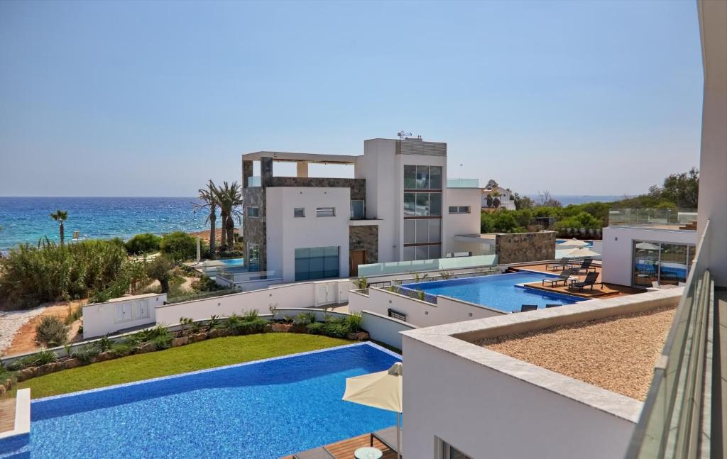 a view of a house with a swimming pool and the ocean at Sea Pearl Luxury Beachfront Villas in Ayia Napa