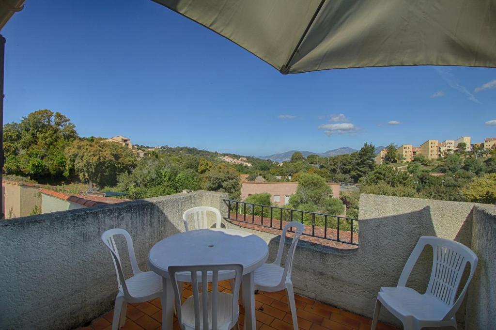 une table et des chaises sur un balcon avec vue dans l'établissement Appartement 318 Paesolu 1 PORTICCIO, à Porticcio