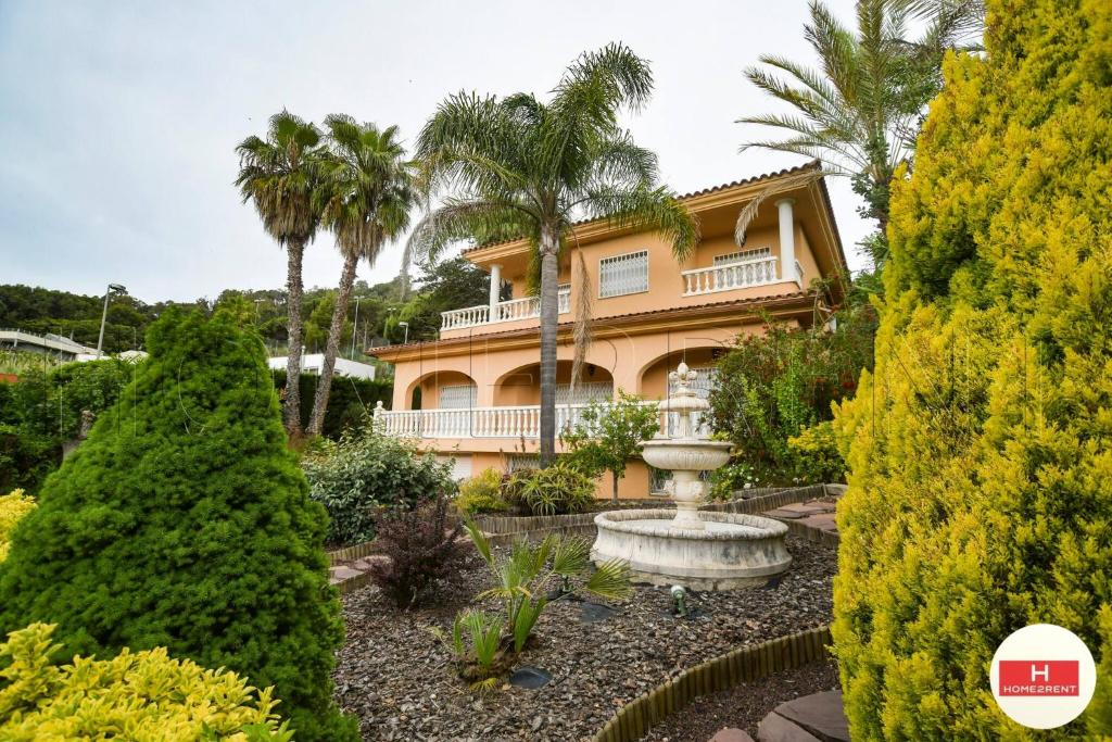 a house with a fountain in front of a garden at Villa Cerca Del Mar num1125 in Blanes