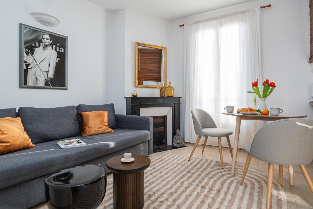 un salon avec un canapé bleu et une cheminée dans l'établissement The Vitry Suite - Duke Housing, à Vitry-sur-Seine