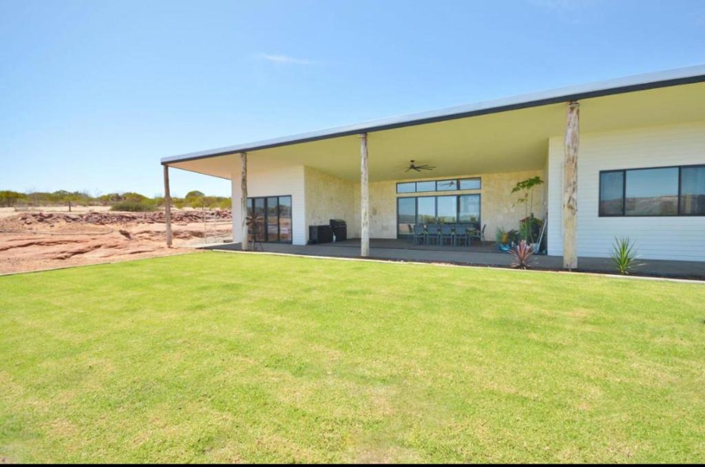 a house with a large lawn in front of it at Off The Hook Kalbarri in Kalbarri