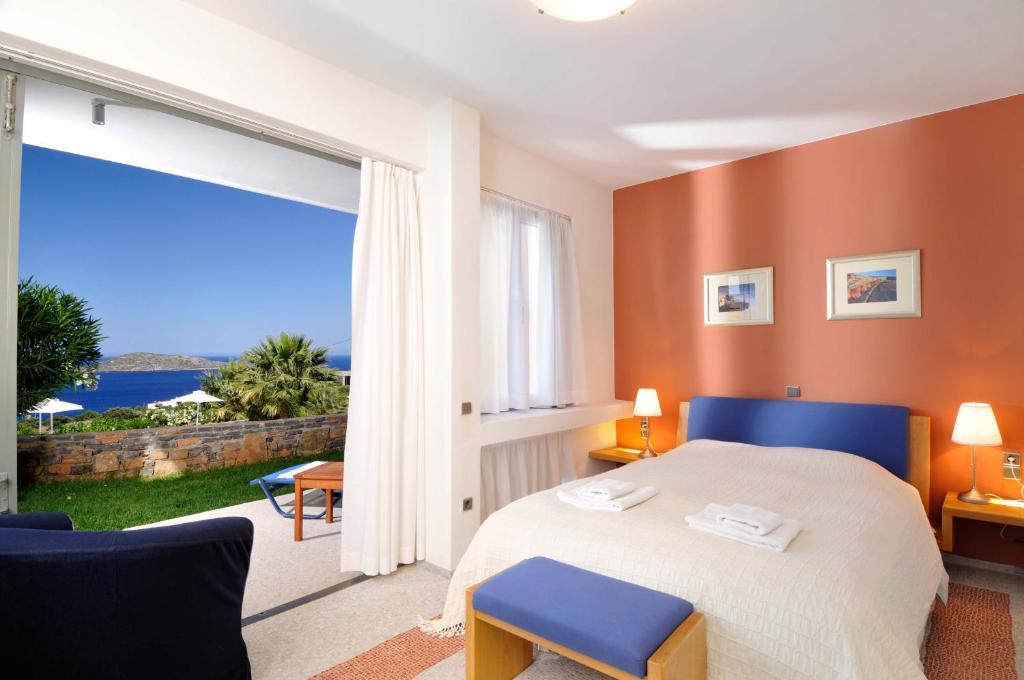 a bedroom with a bed and a large window at Elounda Living Residences in Elounda