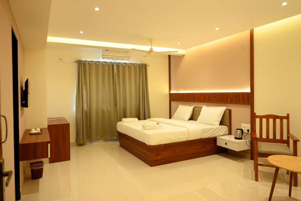 um quarto com uma cama e uma cadeira em Dwaraka Residency em Mangalore