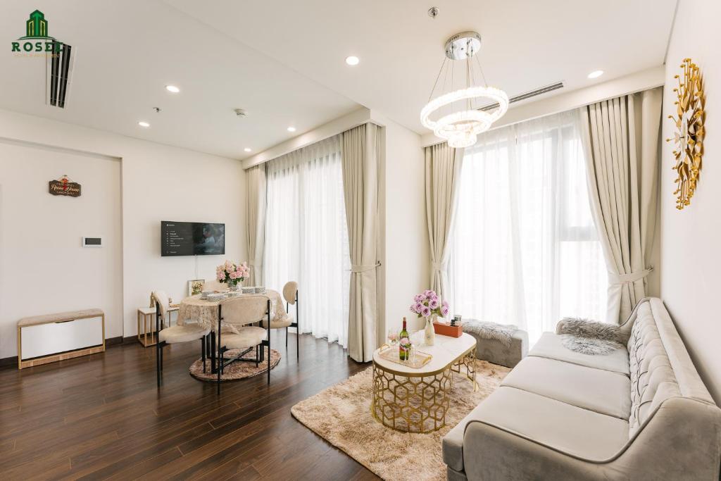 - un salon avec un canapé et une table dans l'établissement Rosee House - Luxury apartment in Vinhomes Smart City, à Nam Tu Liem