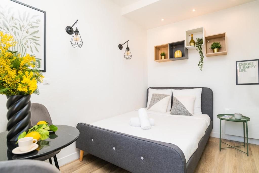 a small bedroom with a bed and a table at The Premium Stay - Duke Housing in Vitry-sur-Seine