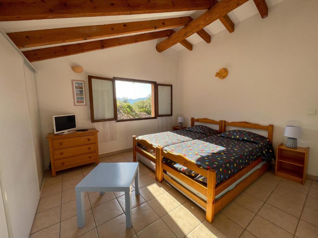 - une chambre avec un lit, une table et une fenêtre dans l'établissement Mini villa Erbalunga, Santa Giulia, à Porto-Vecchio
