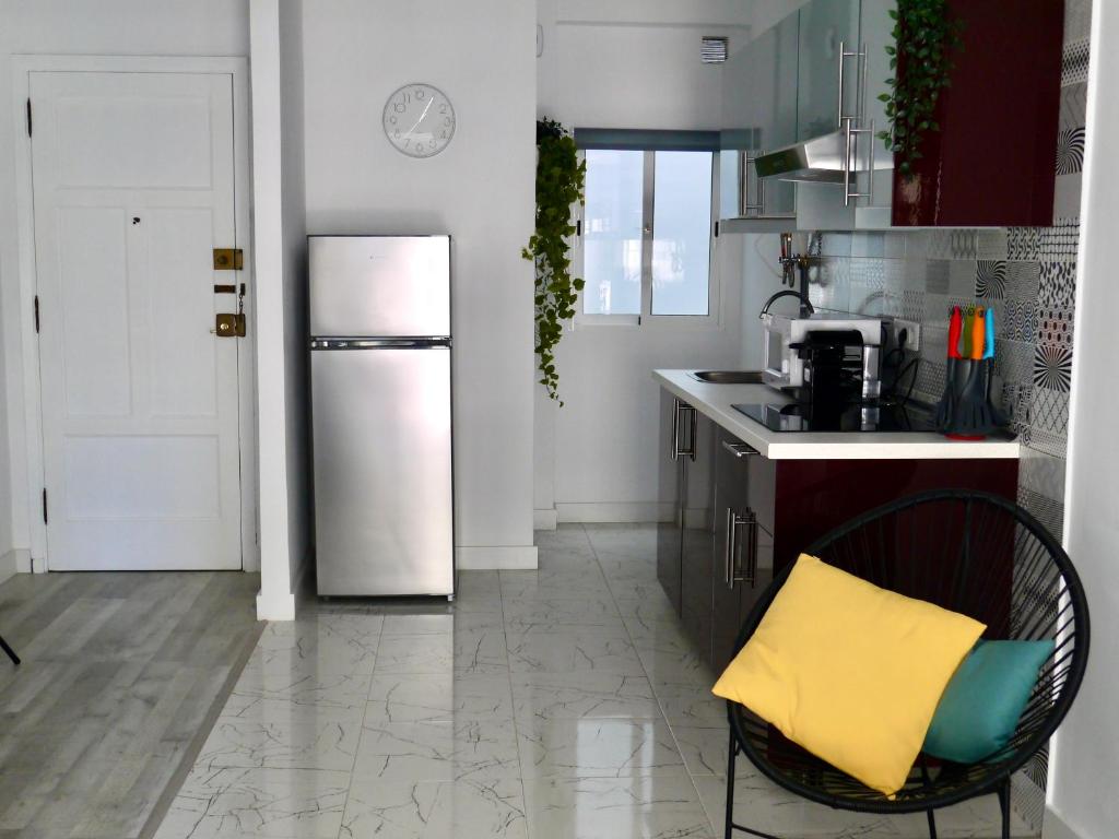a kitchen with a refrigerator and a chair in it at Macaronesia Home in Santa Cruz de Tenerife