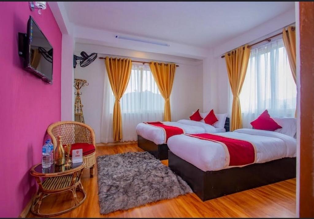 Habitación de hotel con 2 camas y mesa en Mahendra moktan en Dhulikhel