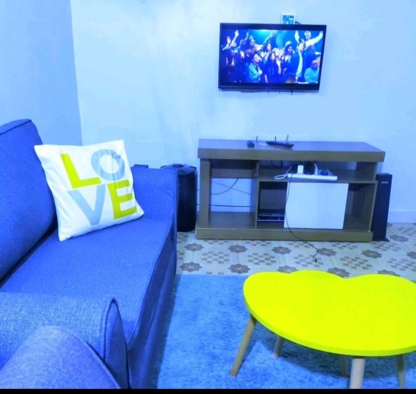 a living room with a blue couch and a table at Tulivu Homes in Embu