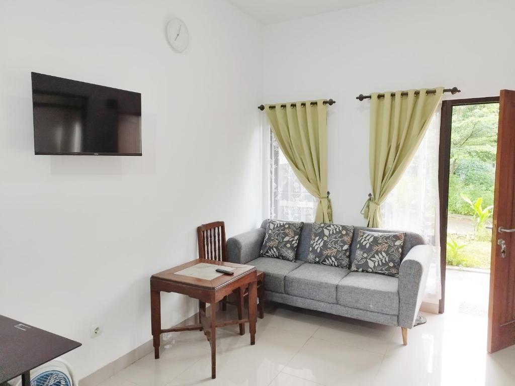 a living room with a couch and a table and a tv at Imah Safina, Cozy Private Home in Padalarang in Padalarang