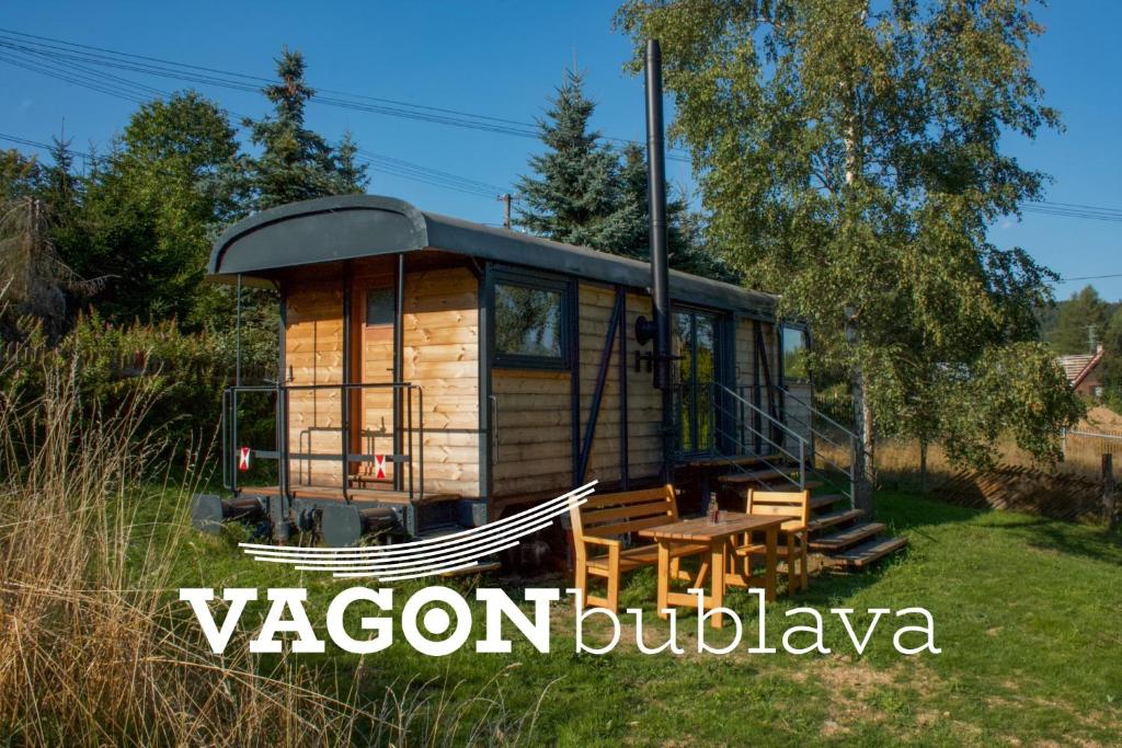 una casa pequeña con una mesa de picnic en un patio en VAGONBublava en Bublava