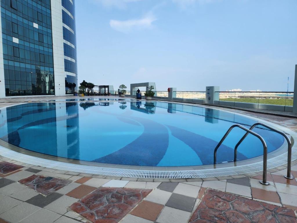 a large swimming pool on top of a building at Comfy Studio with Stunning Vista, Pool and Gym in Abu Dhabi