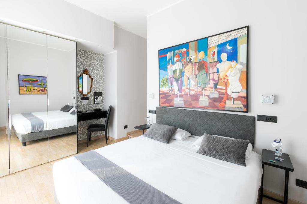 ミラノにあるアイエロ ルームズの白いベッドと壁に絵画が飾られたベッドルーム1室