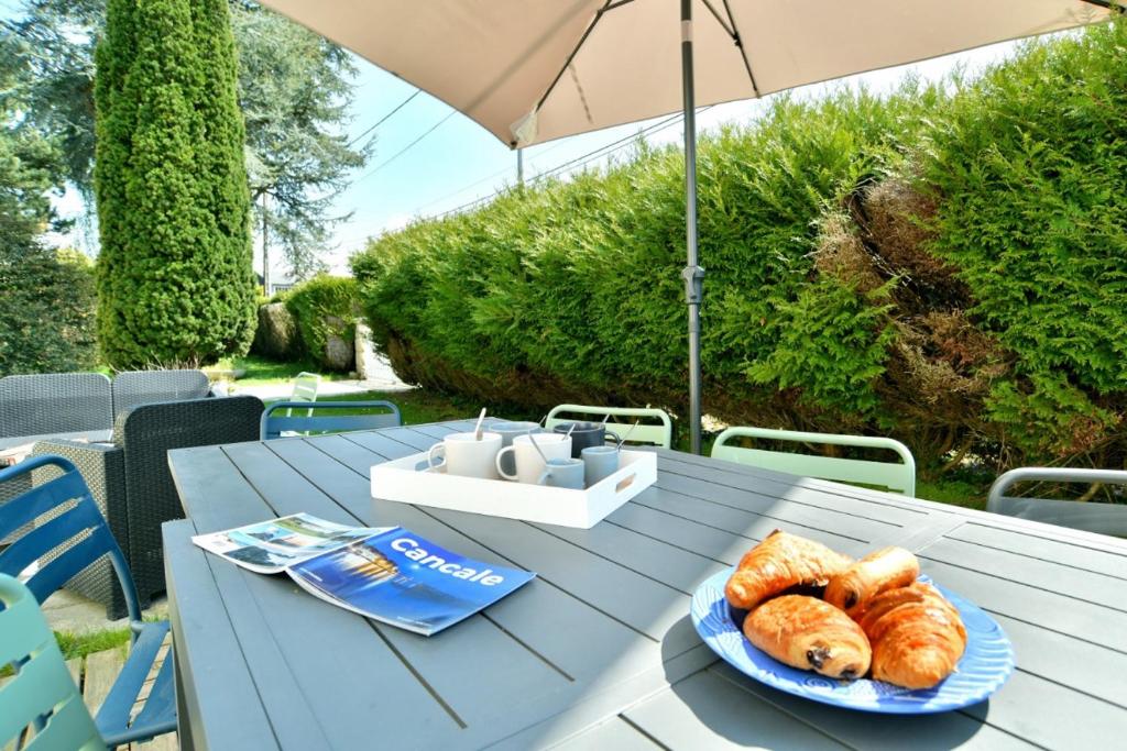ein blauer Tisch mit einem Teller Brot drauf in der Unterkunft Villa des Daules in Cancale