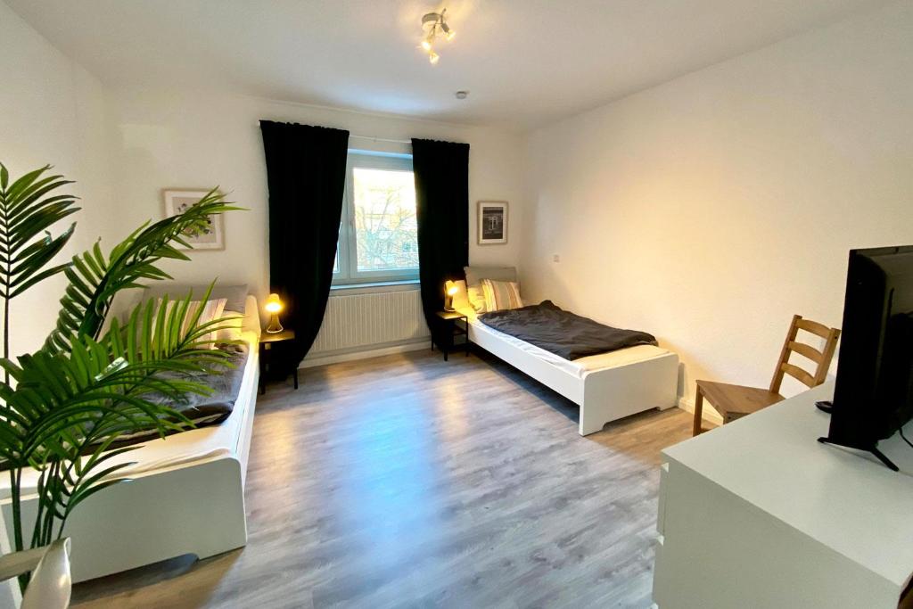 uma sala de estar com duas camas e uma planta em Work & stay apartment in Neuss em Neuss