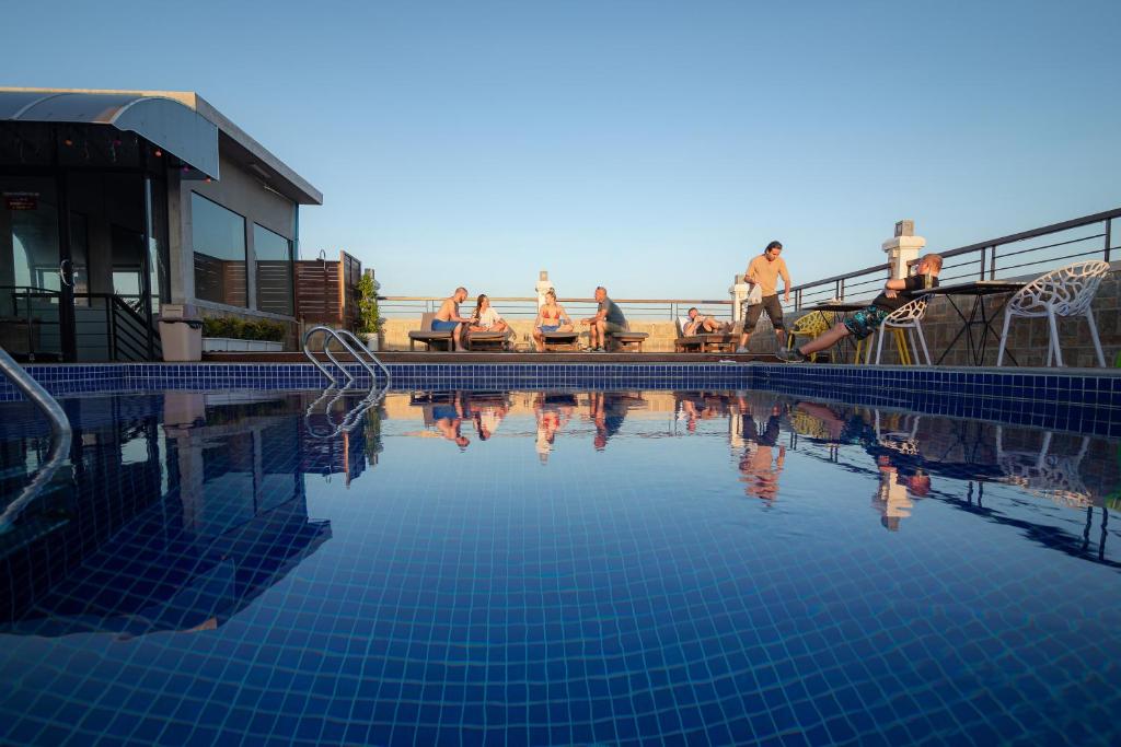 un gruppo di persone seduti intorno alla piscina di Pooltop Phnom Penh a Phnom Penh