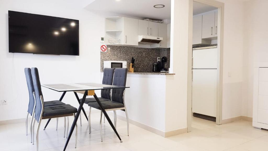 Un comedor con mesa y sillas y una cocina. en Royal II, en Salou