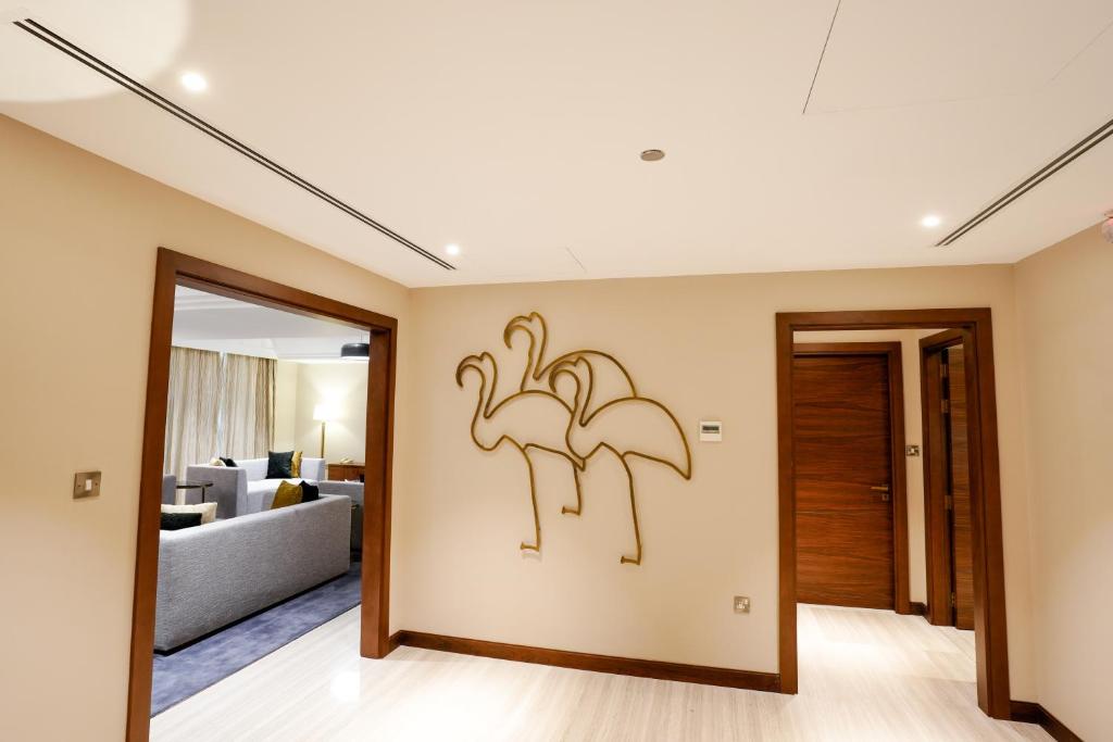 a living room with a painting of flamingos on the wall at Mirfa Hotel in Al Mirfa