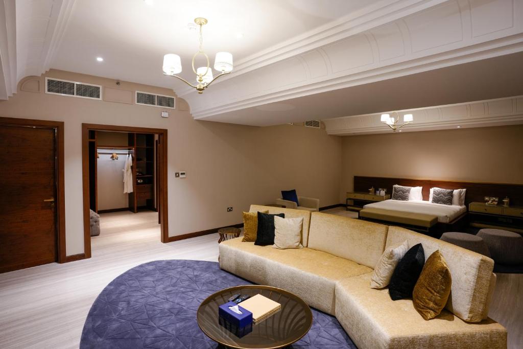 a living room with a couch and a bed at Mirfa Hotel in Al Mirfa