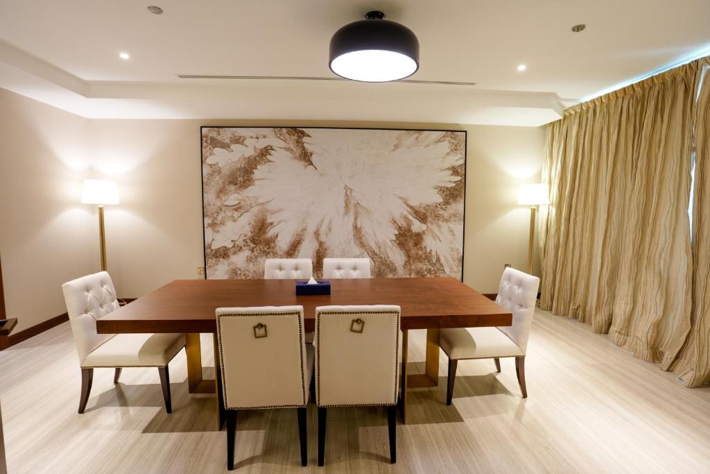 a dining room with a wooden table and chairs at Mirfa Hotel in Al Mirfa