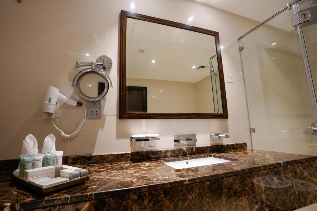 a bathroom with a sink and a mirror at Mirfa Hotel in Al Mirfa