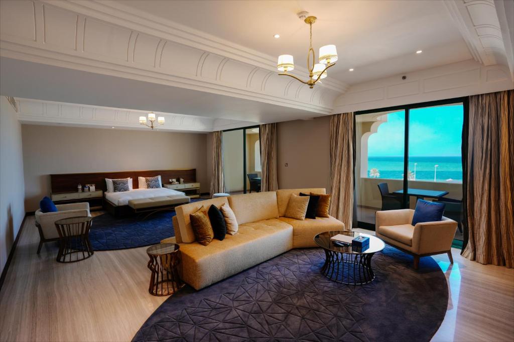 a living room with a couch and a bedroom at Mirfa Hotel in Al Mirfa