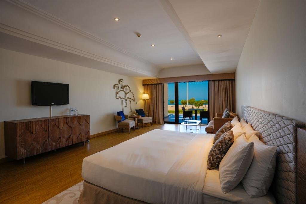 a large bedroom with a large bed and a television at Mirfa Hotel in Al Mirfa
