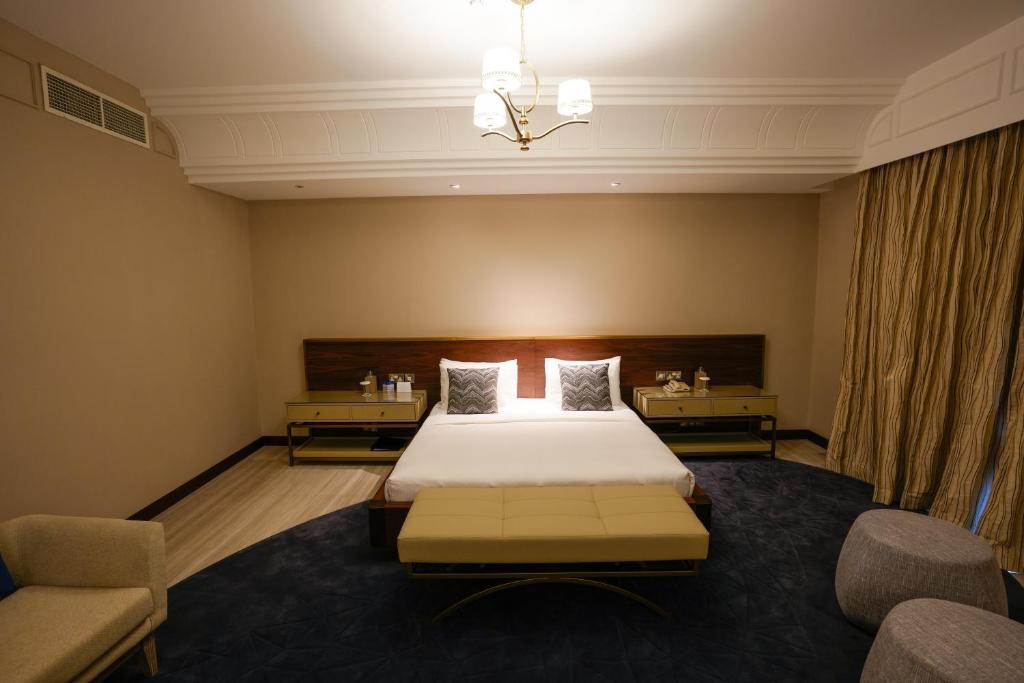 a hotel room with a bed and two chairs at Mirfa Hotel in Al Mirfa