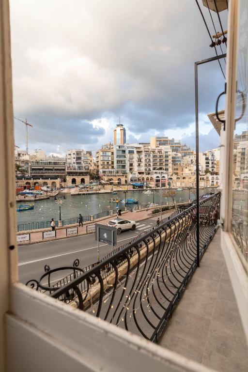 a balcony with a view of a river and buildings at The Rose Hostel in St. Julianʼs