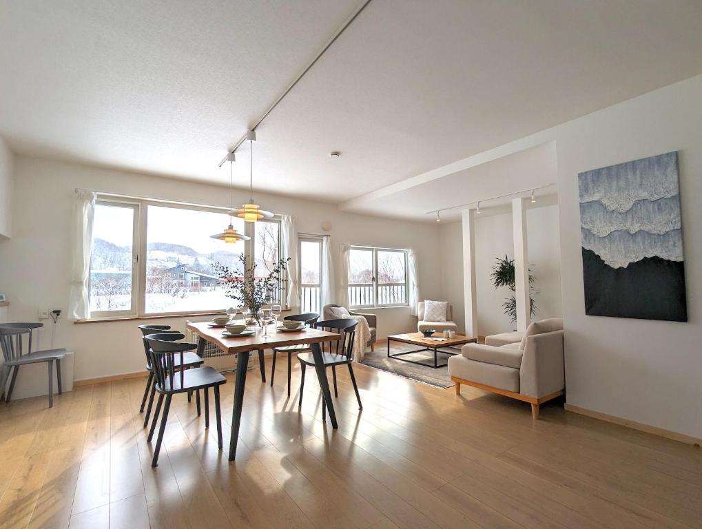 ein Esszimmer und ein Wohnzimmer mit einem Tisch und Stühlen in der Unterkunft Beach Front Fugoppe - spacious & sunny in Yoichi
