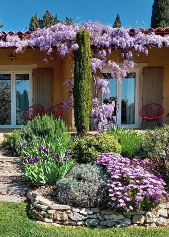 a garden with purple flowers in front of a house at Mas des Marguerites in Maussane-les-Alpilles