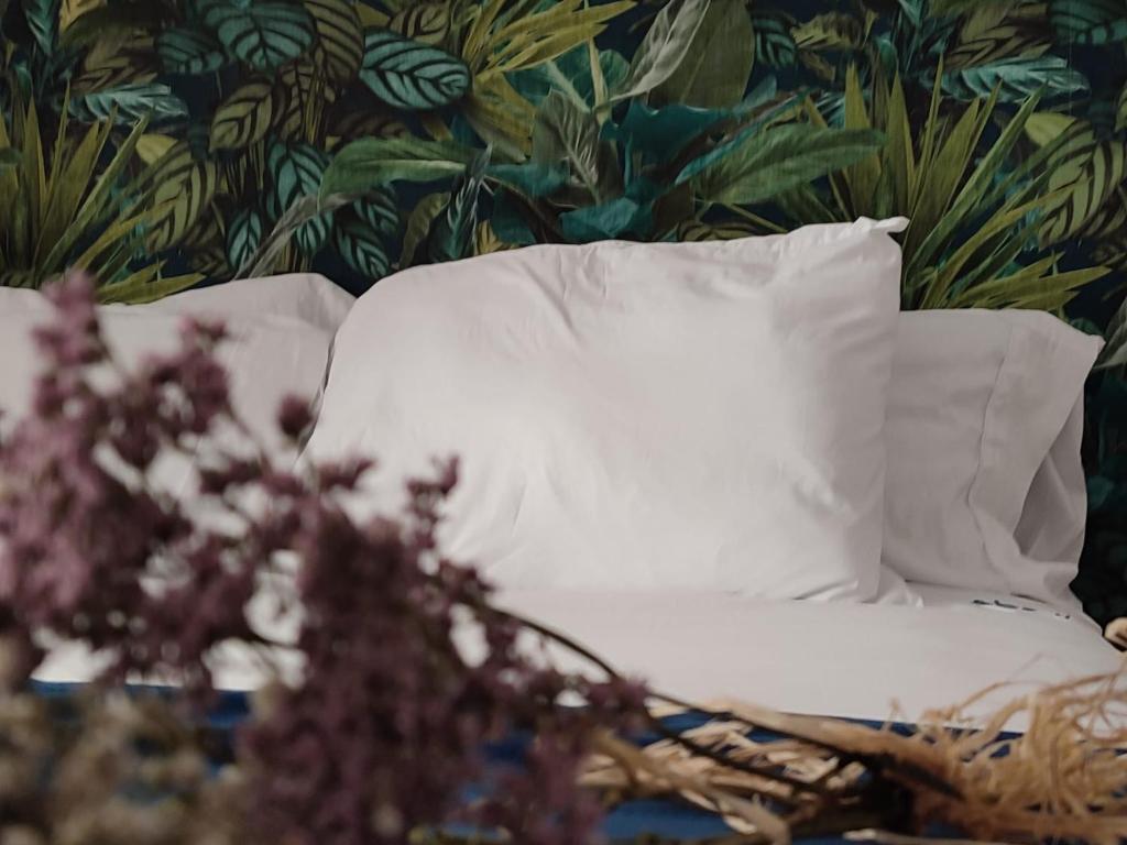 - un oreiller blanc sur un lit avec papier peint floral dans l'établissement Apartamentos Abadía., à Corella