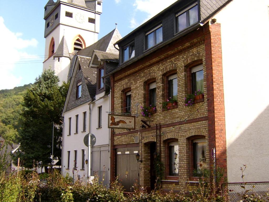 un grand bâtiment en briques avec une tour d'horloge en arrière-plan dans l'établissement Zur Fledermaus, à Bacharach