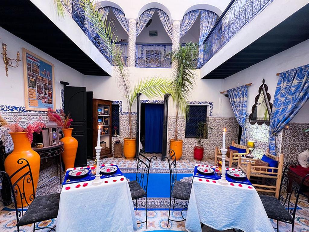 a living room with two tables in a room at Riad Lazord De Marrakech Entier in Marrakesh