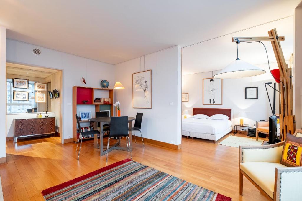 un salon avec un lit et une salle à manger dans l'établissement Veeve - Eiffel Skies, à Paris