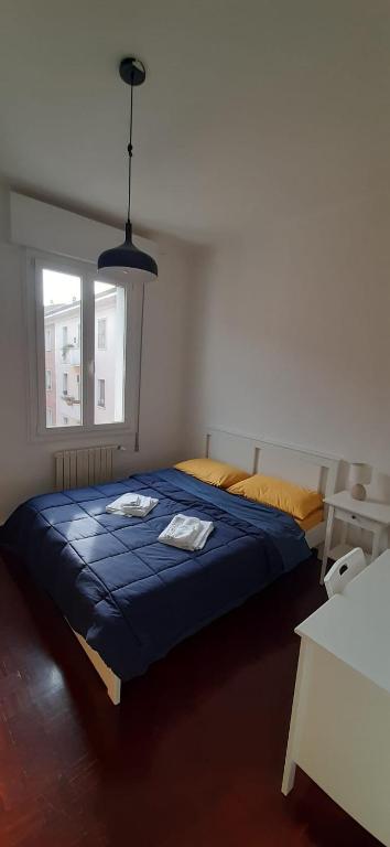 una camera con un letto blu e una finestra di Center rooms Bartolini a Bologna