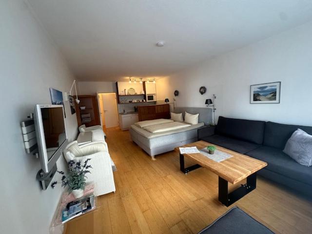 een woonkamer met een blauwe bank en een tafel bij Planke 18 in Norderney