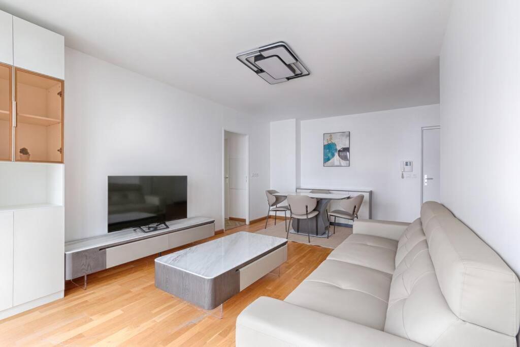 Sala de estar blanca con sofá blanco y mesa en Saint Denis/Leon Nozal : Magnifique Apartment 5P en Saint-Denis
