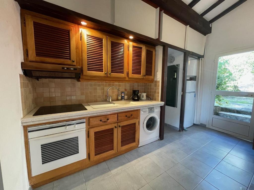 une cuisine avec un évier et une machine à laver dans l'établissement Villa Alando, Santa Giulia, à Porto-Vecchio