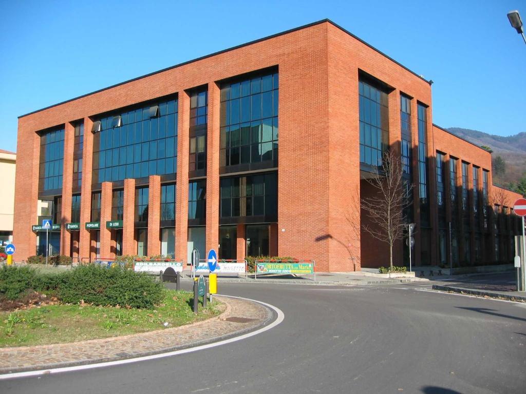 a large brick building with a road in front of it at Residence Le Arcate in Gavirate