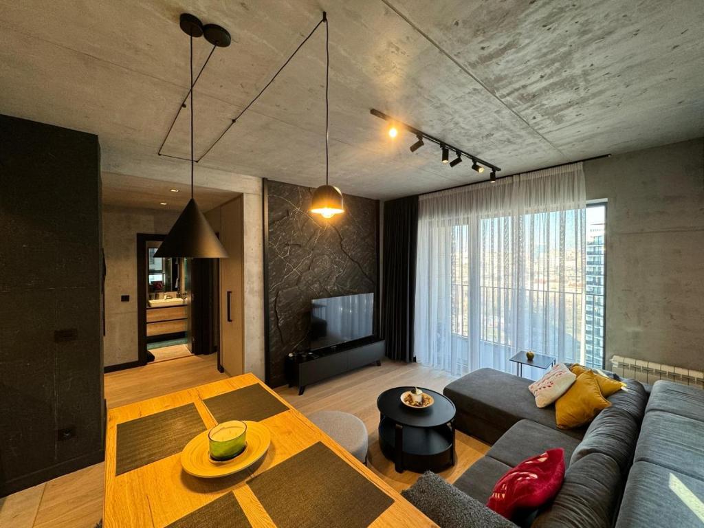 una sala de estar con un sofá y una mesa en Belgrade Waterfront Luxury Apartment, en Belgrado