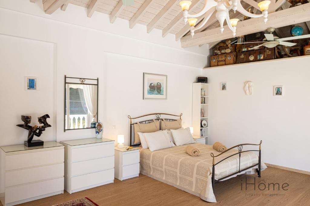 a bedroom with a bed with white walls and a ceiling at The Beach House - Mansion with Swimming Pool in Kámpos