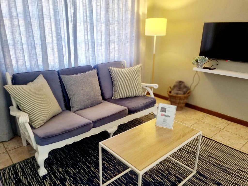a living room with a purple couch and a table at Summerville Place in Addo