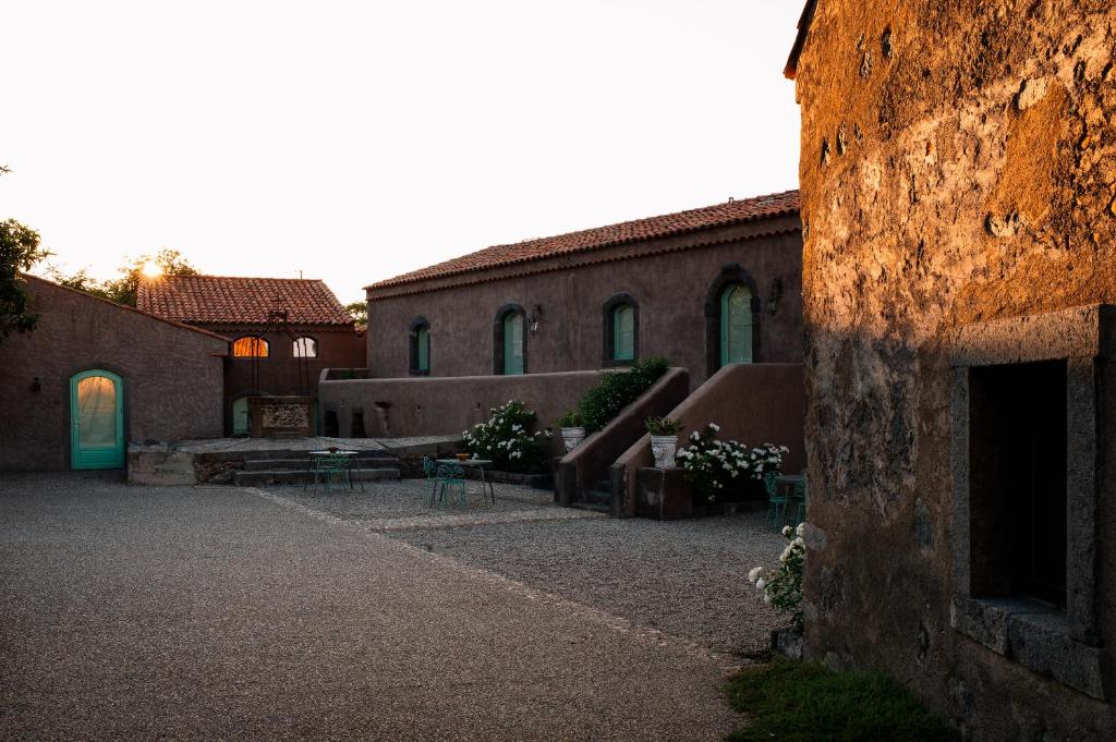 a building with tables and chairs in a courtyard at Tenuta di Fessina in Castiglione di Sicilia