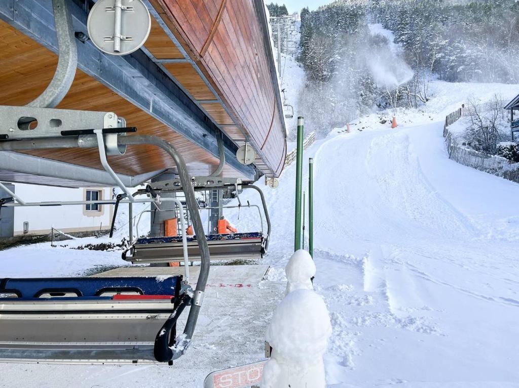 une remontée mécanique est garée sur une piste enneigée dans l'établissement 3 Hab en Arinsal a PIE DE PISTAS - Terraza con Vistas - 1 plaza Parking Incluido, à Arinsal