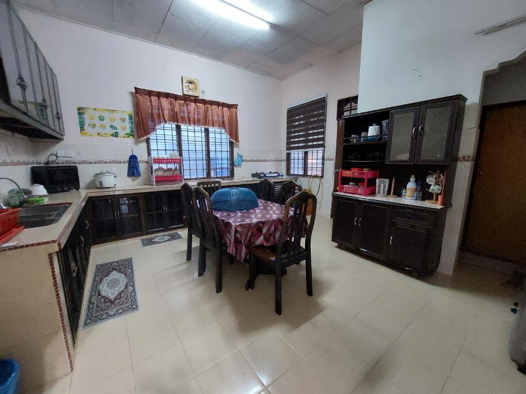 a kitchen with a table and chairs in a room at Rumah Teratak Bonda in Jertih