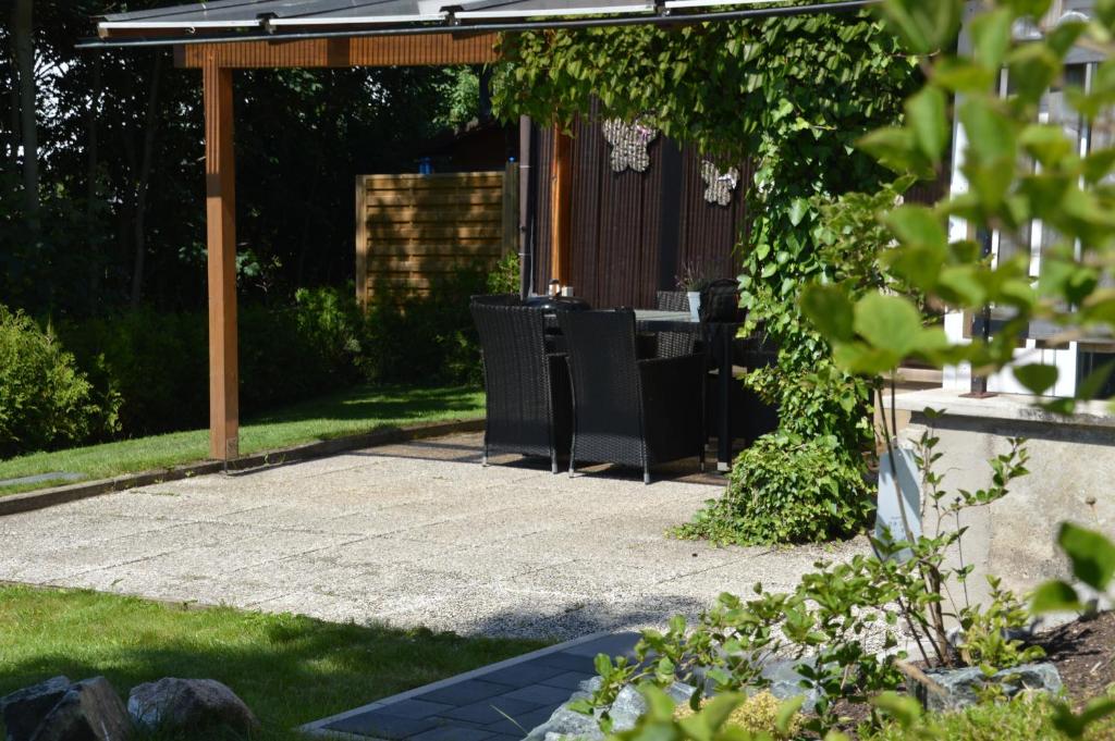 um pátio com uma mesa e cadeiras num jardim em Ferienwohnung Eisblick em Braunlage