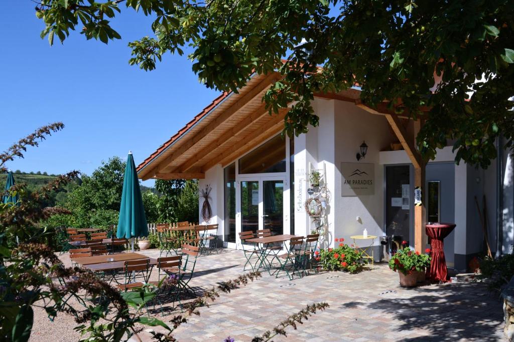 a building with tables and chairs and a umbrella at Am Paradies in Müllheim