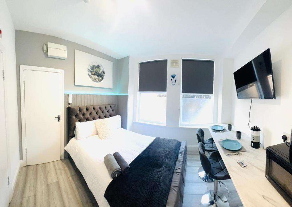 a bedroom with a bed and a desk and a television at Central studios in top location in London