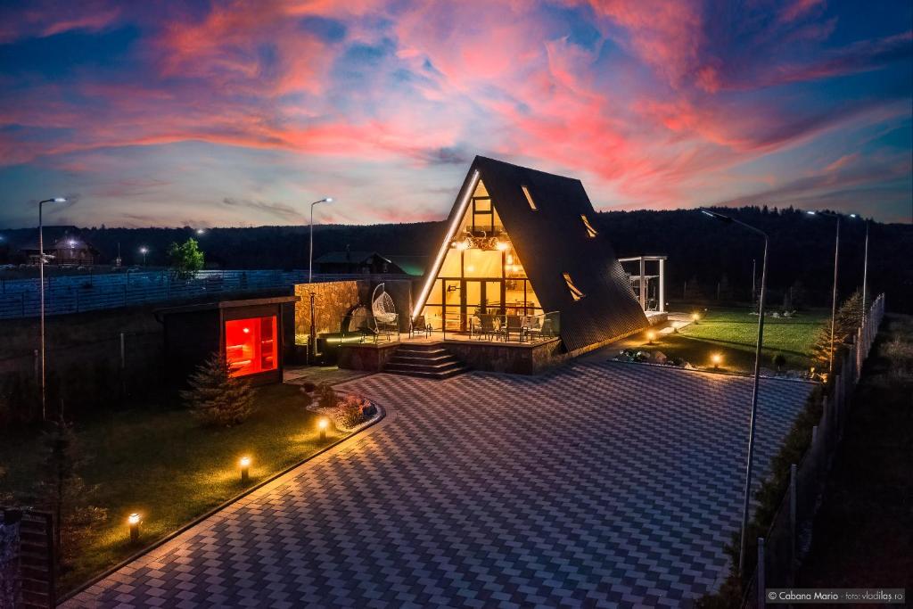 a small building with a red door on a roof at Cabana Mario in Păltinoasa